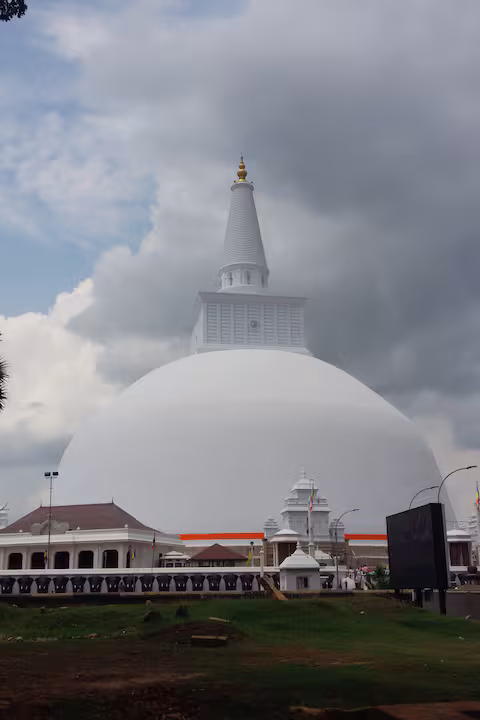 White Anuradhapura stupa beneath dramatic clouds
